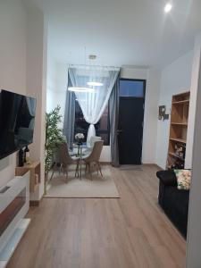 ein Wohnzimmer mit Tisch und Stühlen und einem Fernseher in der Unterkunft El Paseo a Madrid 169 - Junto a la Casa de Campo in Madrid