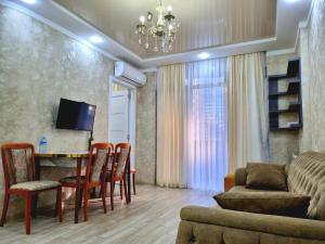 a living room with a table and chairs and a couch at Sea apartment baTumi in Batumi
