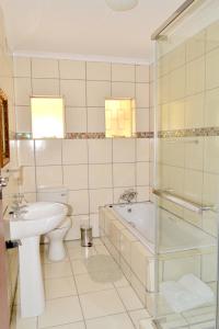 un bagno con lavandino, vasca e WC di Jakobs Guesthouse & Cottage a East London