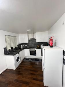 eine Küche mit weißen Schränken und einem weißen Kühlschrank in der Unterkunft New Manchester City Getaway House with 2 FREE Parking in Manchester