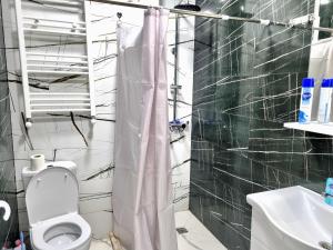 a bathroom with a white toilet and a sink at Sea apartment baTumi in Batumi +8 photos