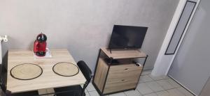 a small room with a desk and a television at "CHIC" Studio avec balcon in Laxou