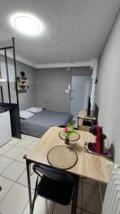 a room with a table and a bedroom with a bed at "CHIC" Studio avec balcon in Laxou