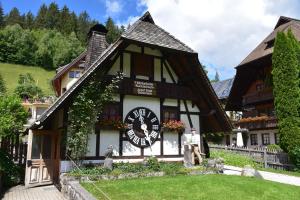 a black and white building with a clock on it at VilaMi Ferienwohnung in Schonwald im Schwarzwald