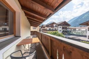 a balcony with a table and chairs and a view at Apartments Alpina in Mayrhofen