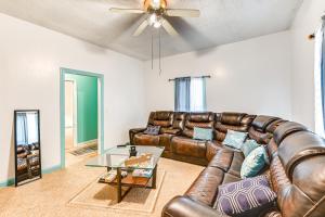 ein Wohnzimmer mit einem Ledersofa und einem Tisch in der Unterkunft 1 Mi to Stadium Home with Porch in Greenville! in Greenville