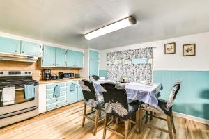 eine Küche mit blauen Schränken und einem Tisch mit Stühlen in der Unterkunft 1 Mi to Stadium Home with Porch in Greenville! in Greenville