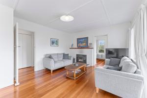 a living room with two couches and a fireplace at Tongariro Base Camp - Turangi Holiday Home in Turangi