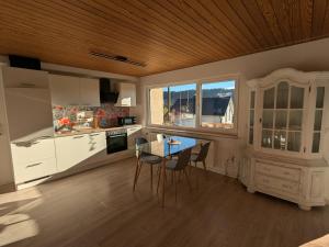 a kitchen with white cabinets and a table and chairs at Ferienwohnung Fornsbachblick in Murrhardt