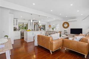 a living room with a couch and a kitchen at Como Palm Retreat in Rye