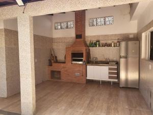 a kitchen with a stainless steel refrigerator in a room at Casa 05 quartos em Marataízes in Marataizes