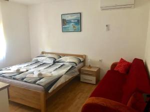 ein Schlafzimmer mit einem Bett und einem roten Stuhl in der Unterkunft Apartments Kate in Zaton