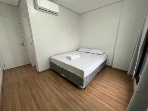 a small bedroom with a bed with white sheets at Bocaiuva 139 - BeXap Stays in Chapecó