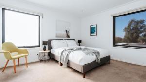 a bedroom with a bed and a chair and a window at Tranquil Shores in Flinders +27 photos