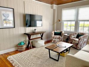 Una sala de estar con un sofá y sillas y un televisor. en Be A Nomad - Beach Bliss - House Perfect for Grps, en Jacksonville Beach