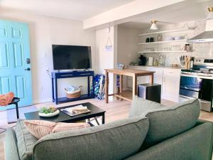 Una sala de estar con un sofá y una mesa y una cocina. en Be A Nomad - Beach Bliss - House Perfect for Grps, en Jacksonville Beach