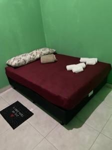 a bed in a room with two towels on it at Casa fechada in Pirenópolis