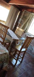 twee houten stoelen en een tafel op een veranda bij El Atardecer in Oro Grueso