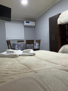 Habitación con 2 camas con sillas y pizarra en Los azahares, en La Cruz