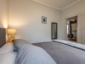 オハクネにあるWillow Lodge - Ohakune Holiday Homeのベッドルーム1室(ベッド2台付)、壁にランプが備わります。