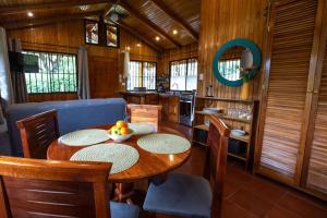 a dining room with a wooden table and chairs at Acogedora cabaña Playa Hermosa Naturaleza y Surf in Playa Hermosa +14 photos