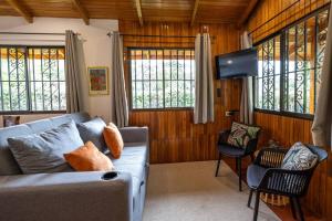 a living room with a couch and a flat screen tv at Acogedora cabaña Playa Hermosa Naturaleza y Surf in Playa Hermosa