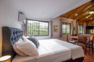 a bedroom with a large bed and a dining room at Acogedora cabaña Playa Hermosa Naturaleza y Surf in Playa Hermosa