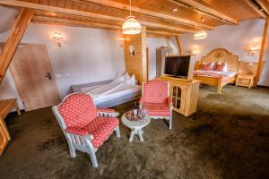 sypialnia z łóżkiem, 2 krzesłami i telewizorem w obiekcie Brandeberg Pension & Restaurant w mieście Bran