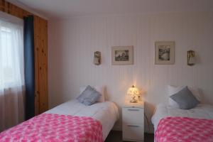 a bedroom with two beds and a lamp on a night stand at Auberge St-Tite-des-Caps in Saint-Tite-des-Caps +53 photos
