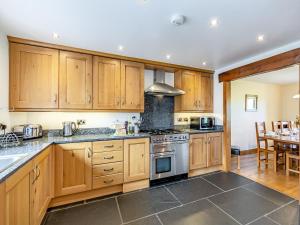 eine Küche mit Holzschränken und Geräten aus Edelstahl in der Unterkunft Warth Barn - Uk44211 in Ingleton 