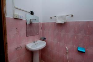 un bagno con lavandino e specchio di Beach Prime Time Hotel a Unawatuna