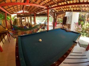 a pool table in a room with a hammock at Casa Bawa in Ubatuba
