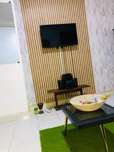 a living room with a table and a flat screen tv at Jolie mini studio américain in Dakar