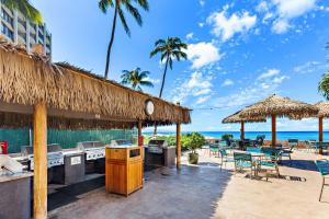 un restaurante en la playa con mesas y sillas en Royal Kahana 1015, en Kahana