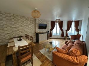 ein Wohnzimmer mit Sofa und Tisch in der Unterkunft Appartement luxueux 2 chambre CENTRE VILLE Langkawi in Chalon-sur-Saône