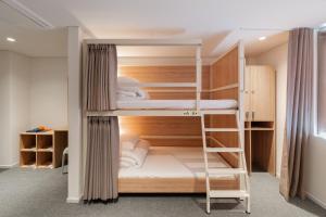 a room with three bunk beds in a room at Mangrove Jeju City in Jeju