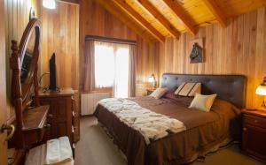 a bedroom with a bed and a window and a television at Cabañas Antuken - Piscina Cubierta - in San Martín de los Andes