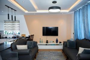 阿克拉iFORA Homes- Stylish 3 Bedroom Condo near A&C Mall的客厅配有沙发和墙上的电视