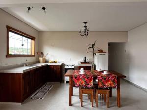 a kitchen with a table with chairs and a kitchen with a sink at Serra Vale D l 2 Suítes l Centro Histórico l Garagem in Tiradentes