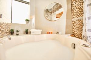 a white bath tub in a bathroom with a mirror at Inti Tampu Inn in Cusco +72 photos
