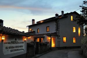 a white house with yellow lights on the windows at Agriturismo Borgo Mocale in Castelfranco di Sopra