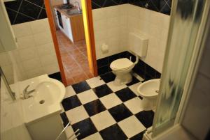 a bathroom with a black and white checkered floor at Apartment Dragun in Pula