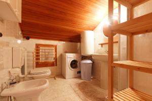 un bagno con un lavandino del water e una lavatrice di Testa Grigia a Champoluc