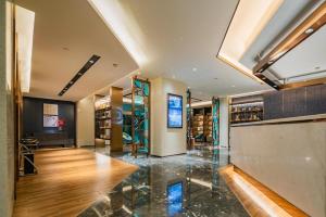 a lobby with a glass counter and wooden floors at Yitel Xi'an Hi-tech Zone Wanda Plaza in Xi'an