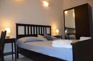 1 dormitorio con 1 cama con sábanas azules y espejo en Ro.Ri. Rooms en San Vito lo Capo