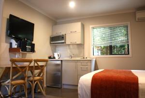 a small kitchen with a table and chairs in a room at Albert Court Motor Lodge in Hamilton
