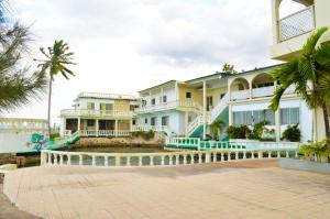 um grande edifício com palmeiras em frente em Sahara dela Mer Inn em Montego Bay