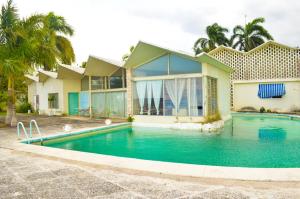 a house with a swimming pool in front of a house at Sahara dela Mer Inn in Montego Bay