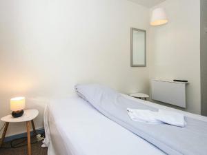 a bedroom with a bed and two tables and a mirror at Lush cabin in camping resort in Aabenraa