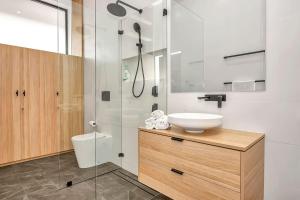 a bathroom with a toilet and a sink and a shower at Birdy Beach House - An Idyllic Oceanfront Lifestyle in Grange +16 photos